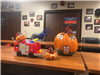 Pumpkin decorated as house on fire; other pumpkins decorated as firefighters with a small fire truck
