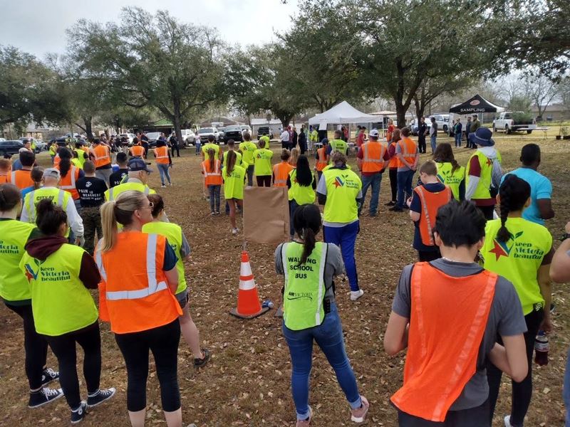 Large group of people in park with work vests, some with KVB logos