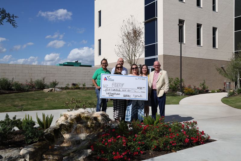 Group photo with a giant check at a garden at UHV