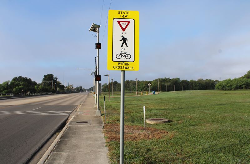A crosswalk at one end of the Lone Tree Creek trail with a Yield sign