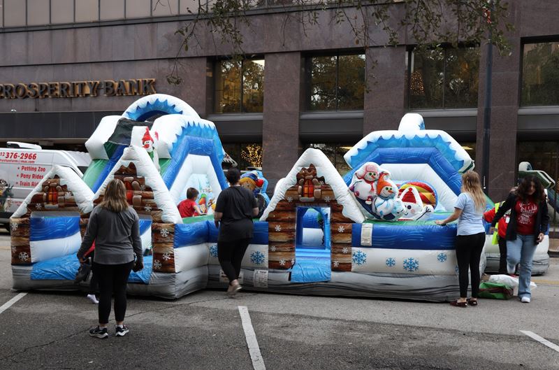 A bounce house style inflatable that looks like a snowy cabin with snowmen
