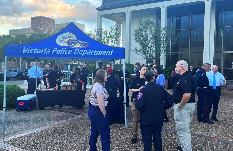 Large group of people standing around the City Hall courtyard. VPD canopy covers a refreshment table