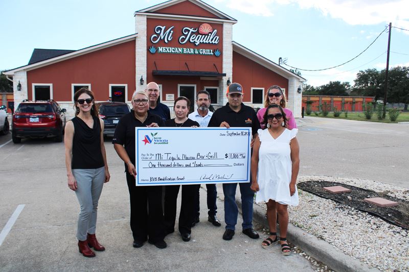 Group photo with giant check in front of Mi Tequila Mexican Bar and Grill