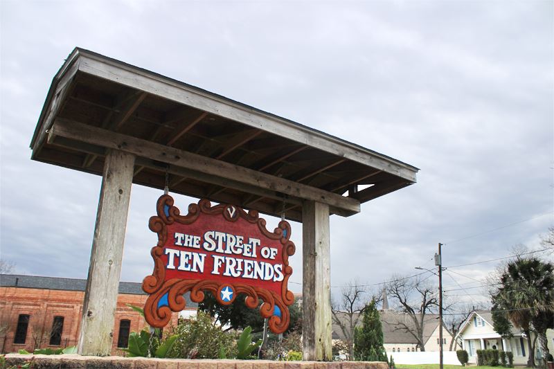 Street of Ten Friends sign against a cloudy sky backdrop