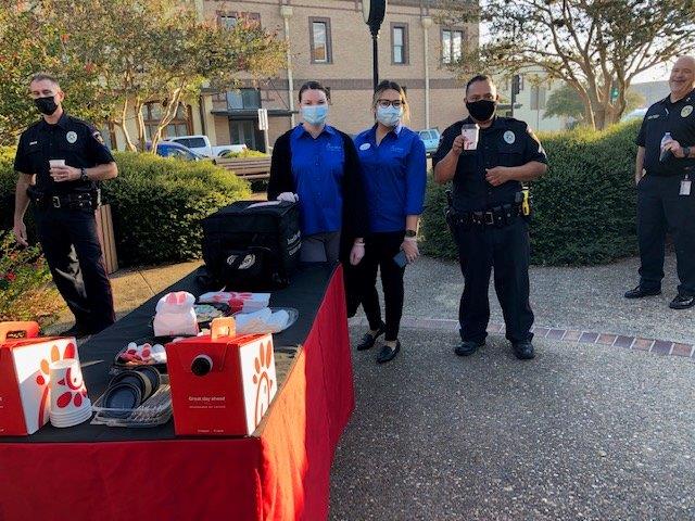 Police officers pose for a photo with Chik-fil-A staff near the Chik-fil-A booth.