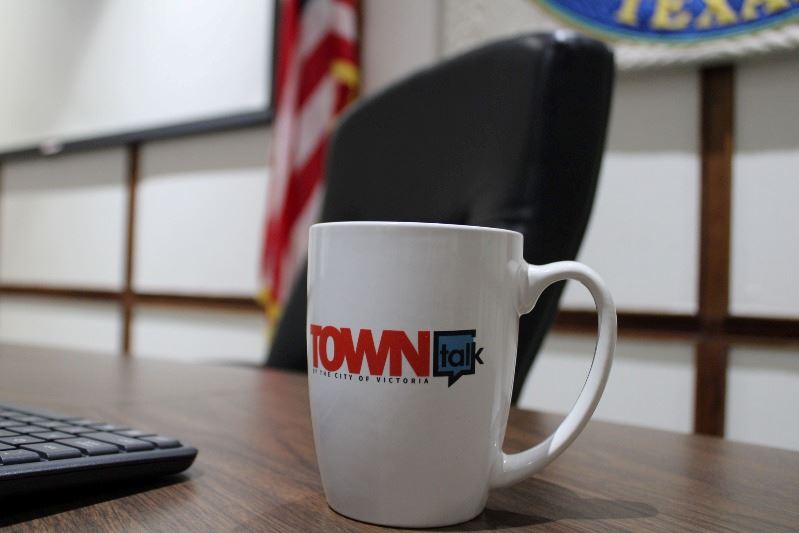 A coffee cup with the TOWNtalk podcast logo sits at the judge's bench at Municipal Court.