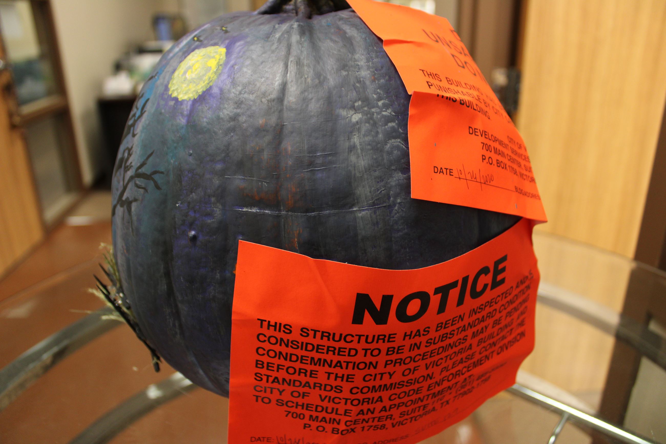 Pumpkin painted as eerie house with dark sky and moon