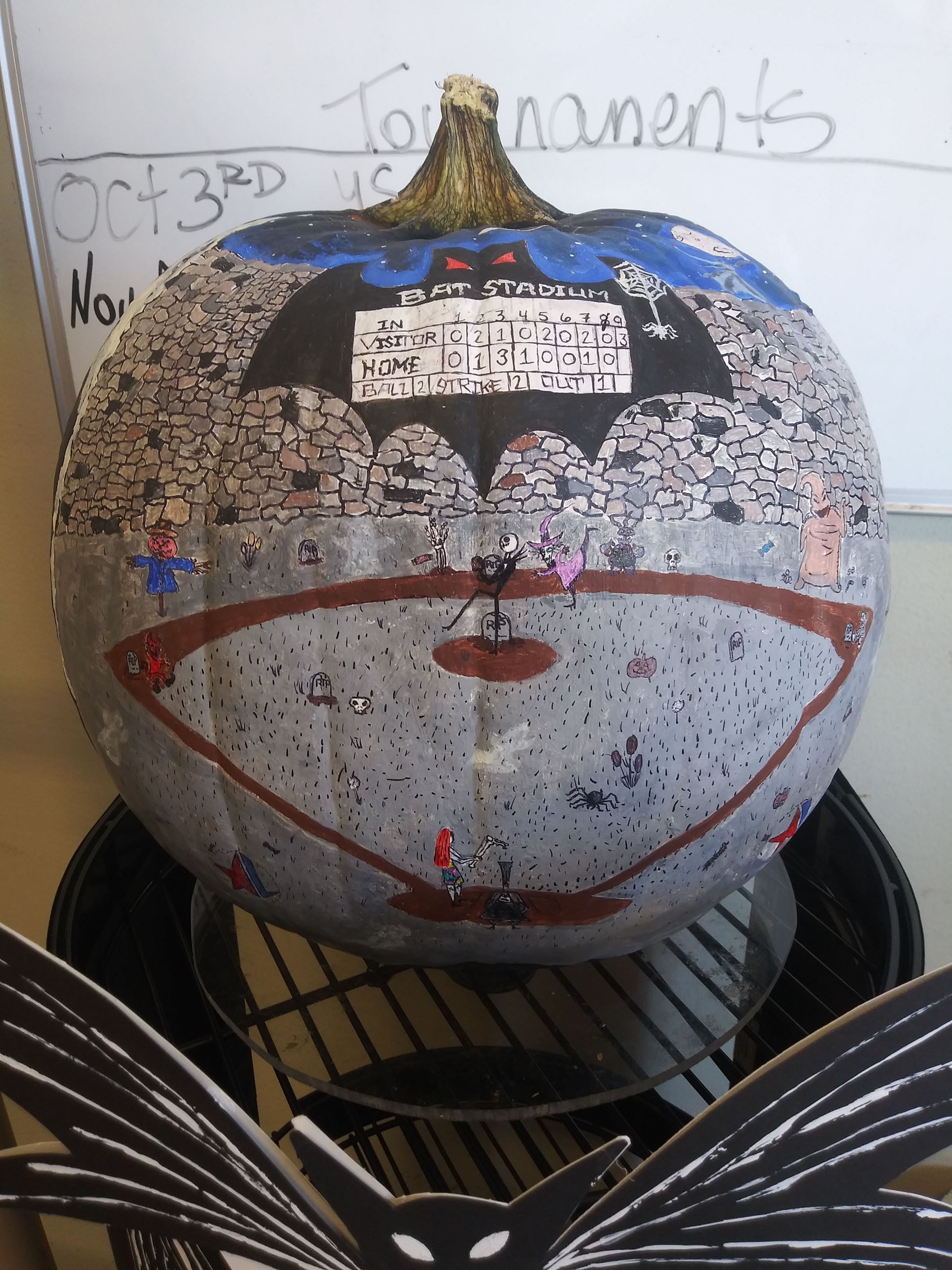 Pumpkin painted with scene of characters from The Nightmare Before Christmas playing baseball.