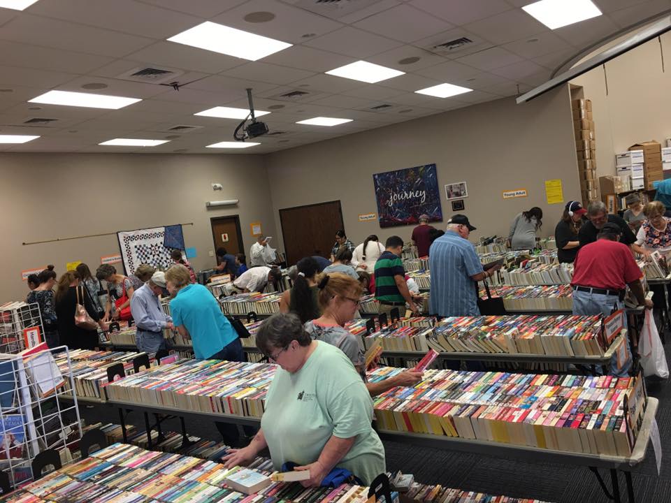 In library's Bronte Room, people gather around tables filled with makeshift bookshelves.
