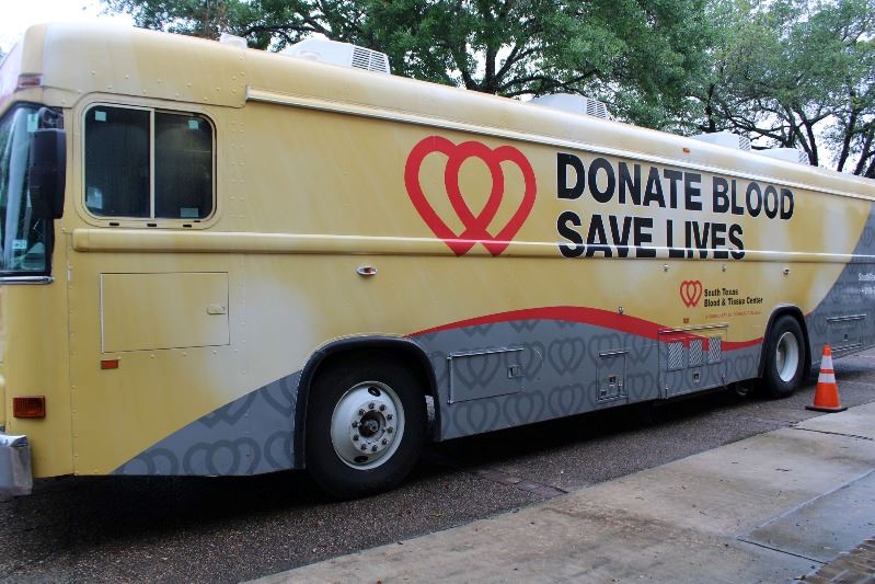 Bus-style vehicle with the South Texas Blood and Tissue Center logo. Donate Blood, Save Lives.