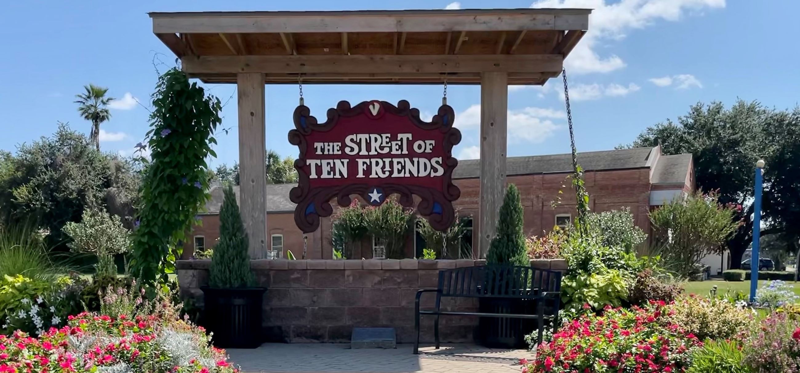 Street of Ten Friends Sign entering Downtown Victoria with bench and flowers