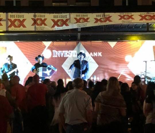 Singer, guitarist and accordion player perform for a crowd on an outdoor stage
