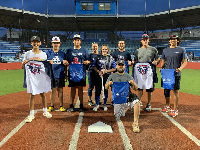 Group photo of people holding Parks & Recreation shirts and drawstring bags