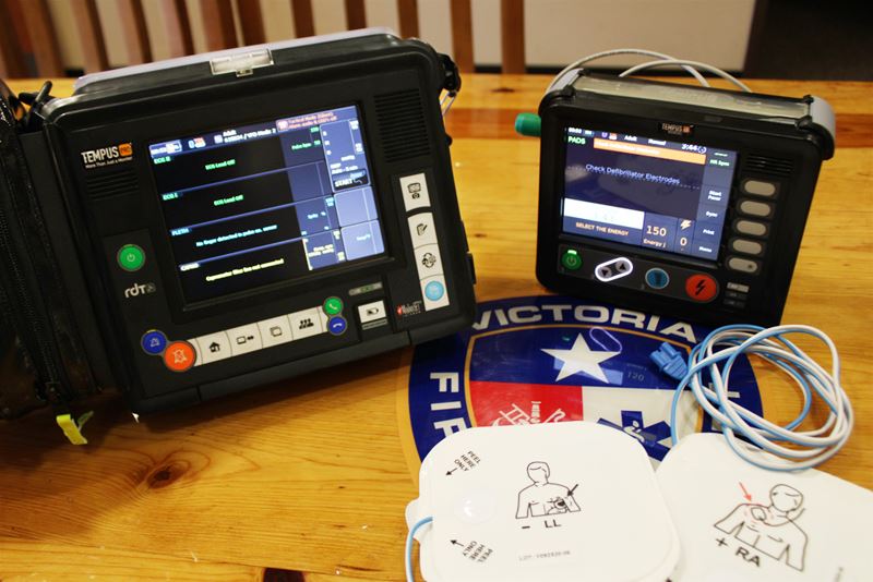 Cardiac monitor and EKG machine on a table with a fire department logo
