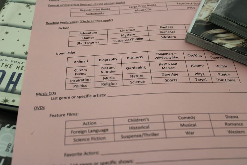 A pink paper form where the user can select library material types and genres