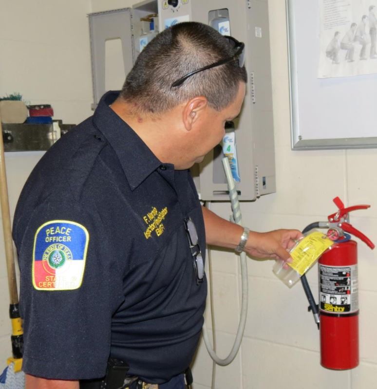 Fire fighter inspecting a fire extinguisher