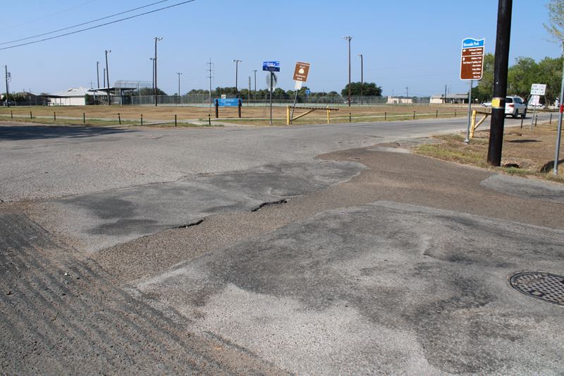 Vine Street shows signs of damage and unevenness near the McCright Drive entrance to Riverside Park