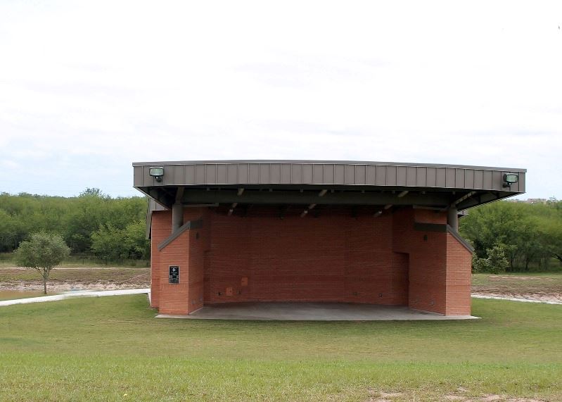 A large brick amphitheatre at the bottom of a grassy hill
