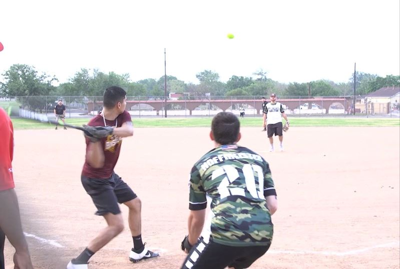 A player swings a bat during a game of softball