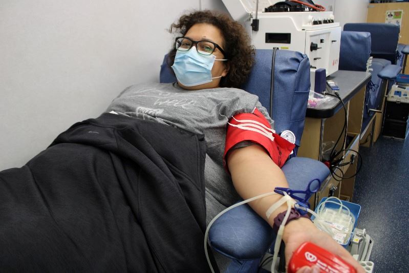 Woman is hooked up to blood donation unit.