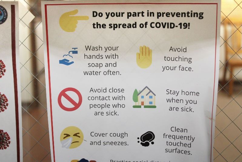 Sign on how to stop COVID-19: Wash hands. Avoid touching face. Stay home if sick. Etc.