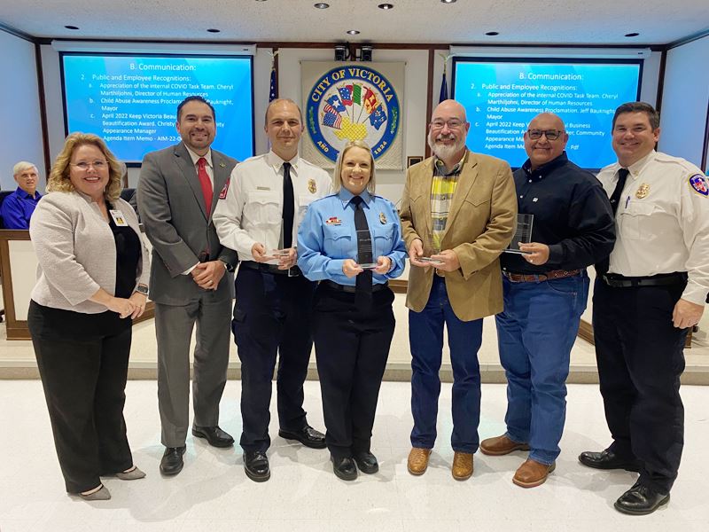 Small group photo at Council chambers. Four people hold plaques starting third from left.