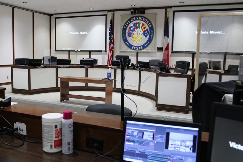 A Zoom feed is projected to both screens in the municipal courtroom.